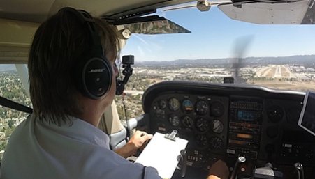 Pilot in the cockpit of a small plane landing at Van Nuys airport